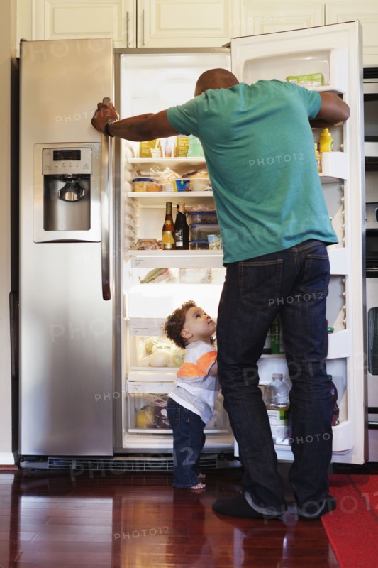 Father and baby looking through fridge