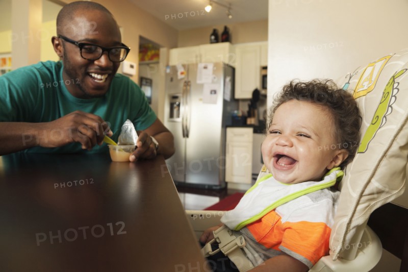 Father feeding baby at table