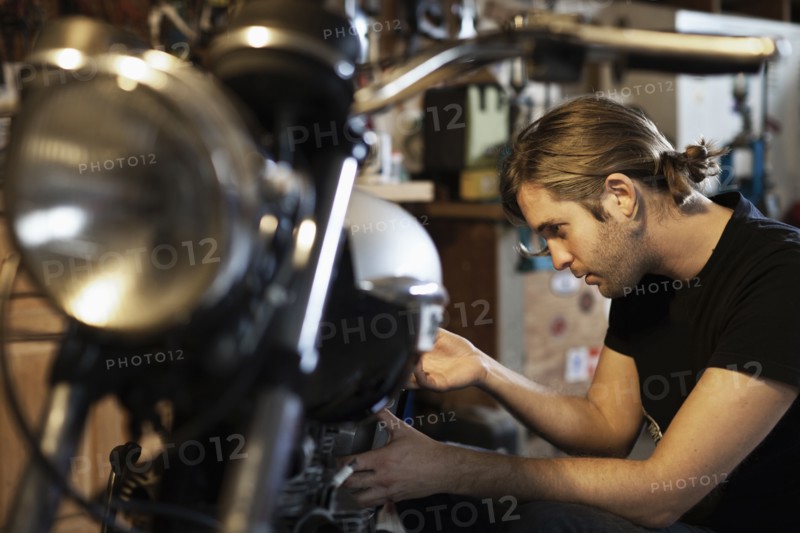 Caucasian mechanic working on motorcycle