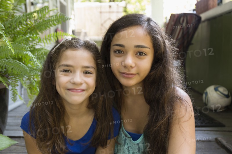 Mixed race sisters sitting outdoors
