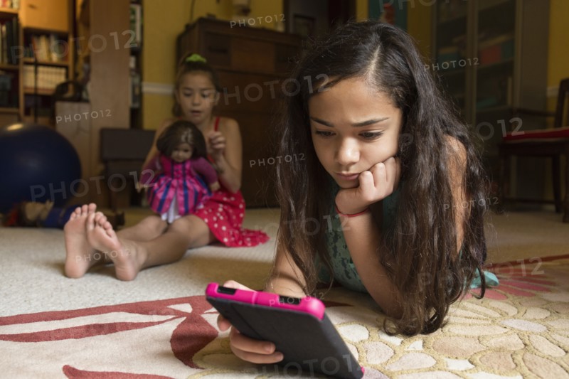Mixed race girl using digital tablet on floor