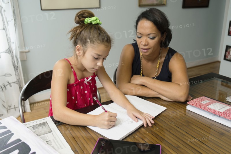 Mixed race mother helping daughter with homework