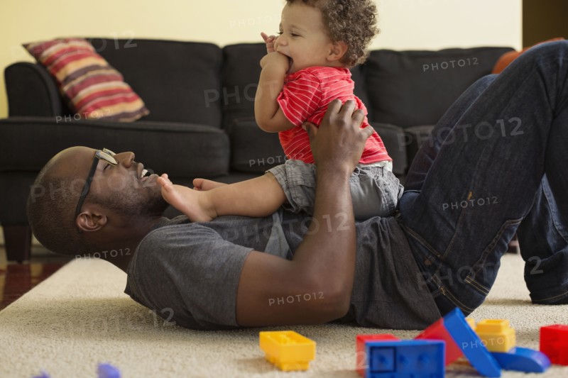 Father and toddler son playing in living room