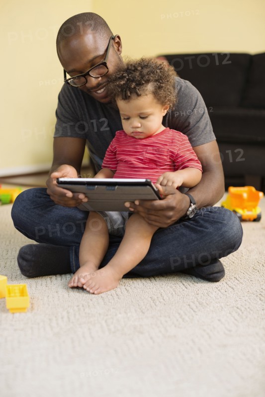 Father and toddler son using digital tablet