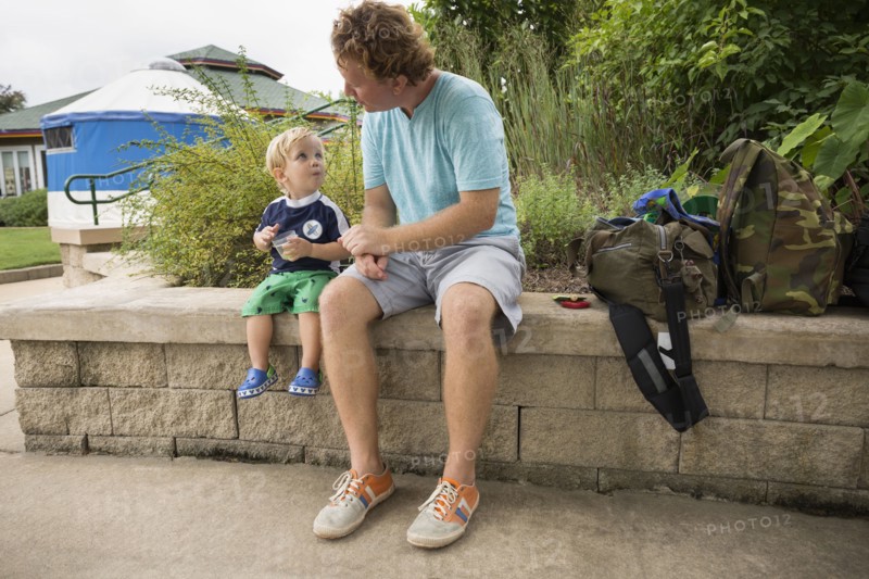 Caucasian father and toddler son sitting in park
