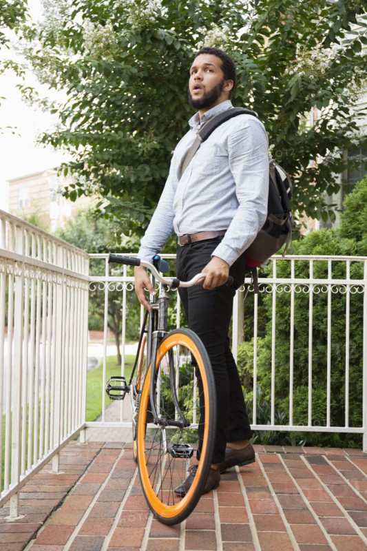Mixed race businessman with bicycle on front stoop