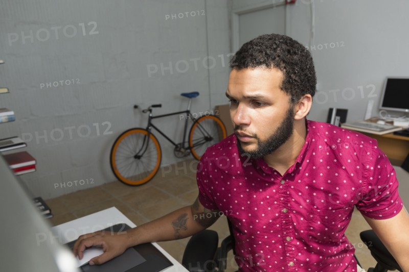 Mixed race businessman sitting at desk