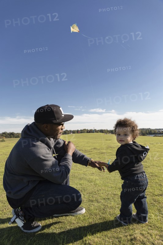 Father and son flying kite in park