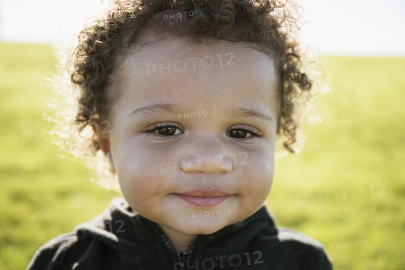 Close up of mixed race baby boy with curly hair