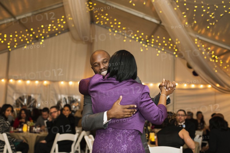 Black groom dancing with mother at reception