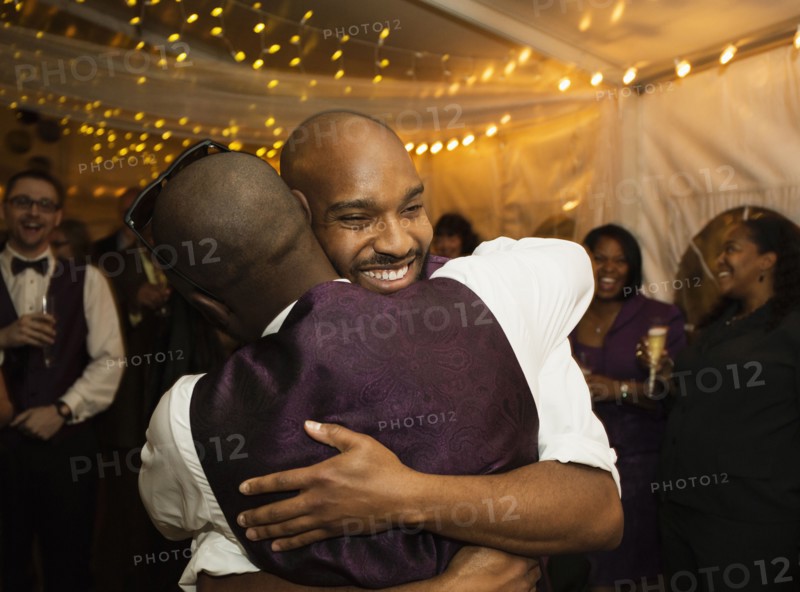 Groom hugging groomsman at reception