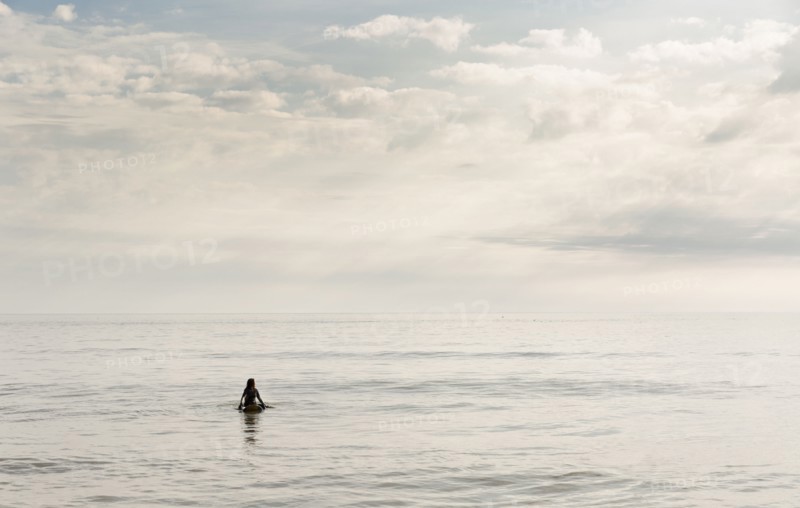 Hispanic surfer floating in water