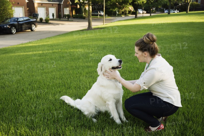 Caucasian woman petting dog in park