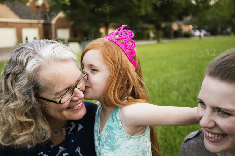 Three generations of Caucasian women sitting in park
