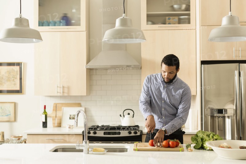 Mixed race man cooking in kitchen
