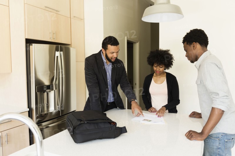 Couple talking to broker in new house
