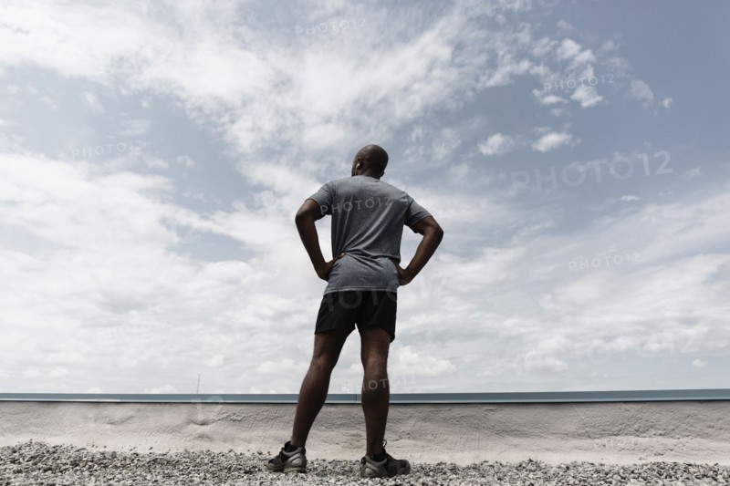 Black runner contemplating landscape
