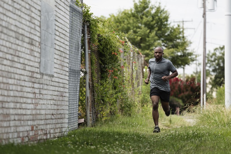 Black man running in urban grass
