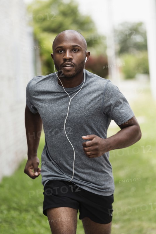 Black man running in urban grass