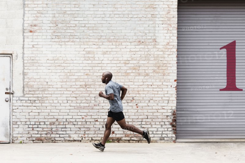 Black man running on city sidewalk