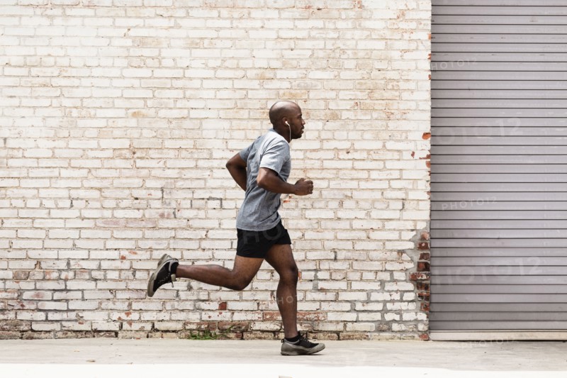 Black man running on city sidewalk
