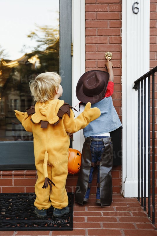 Boys in costumes trick or treating together on Halloween