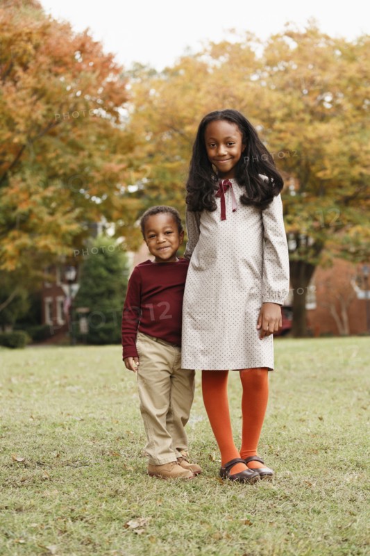 African American brother and sister smiling in park