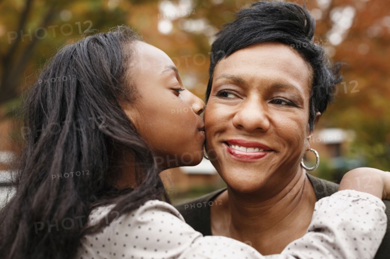 Close up of African American girl kissing mother