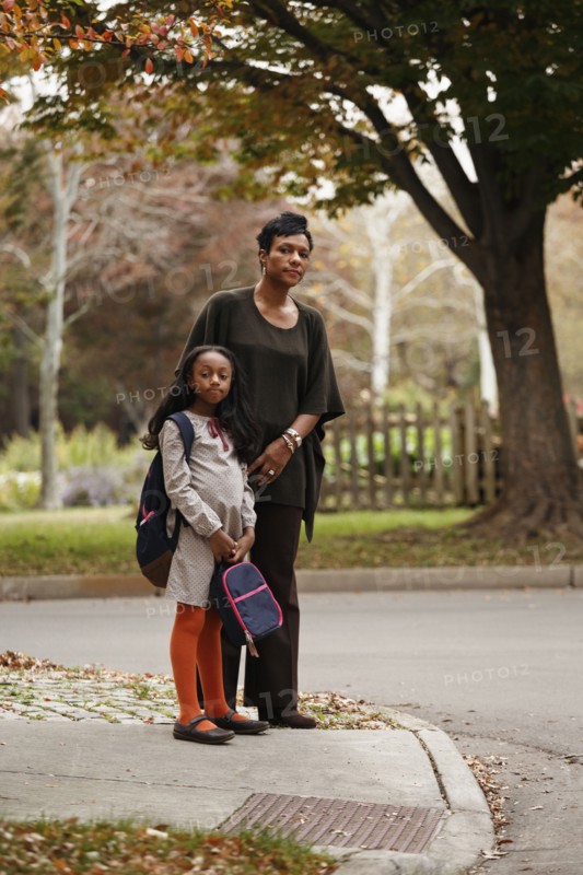 African American woman and daughter waiting for school bus