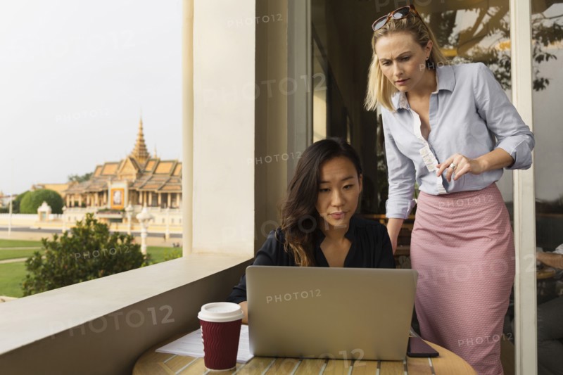 Businesswomen working on laptop in cafe