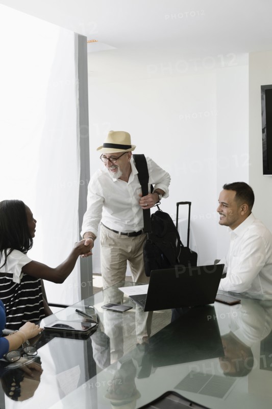 Businessman greeting colleagues in office meeting