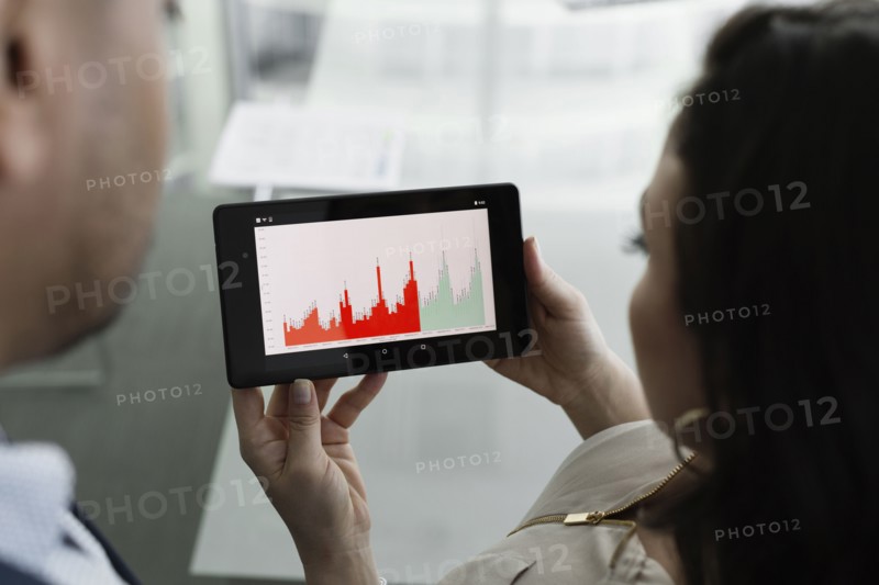 Business people viewing graph on digital tablet