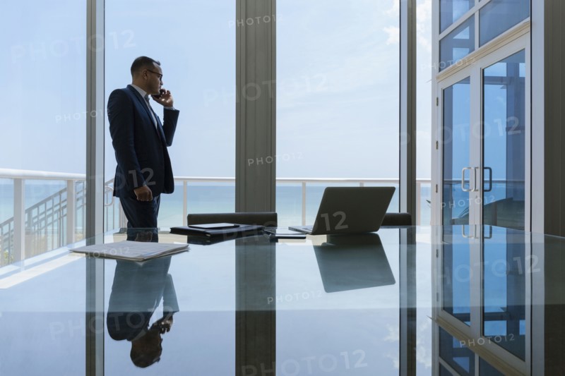 Hispanic businessman talking on cell phone in conference room
