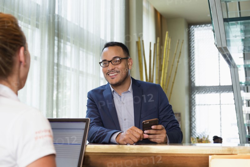 Businessman checking into hotel with concierge