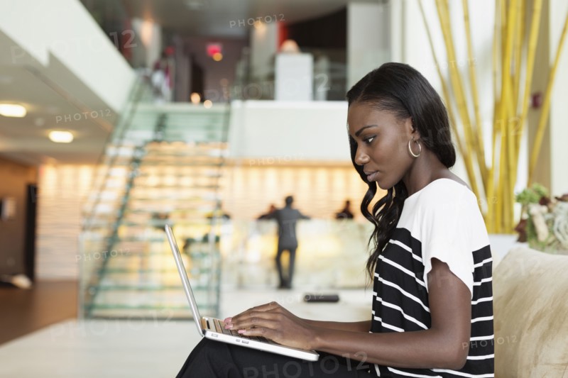 Businesswoman using laptop in hotel lobby