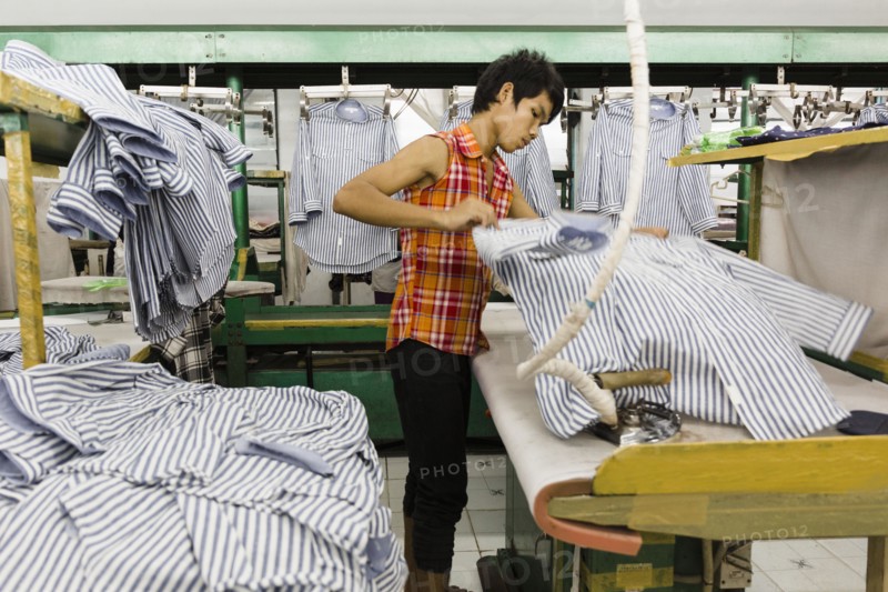 Asian worker ironing shirt in garment factory