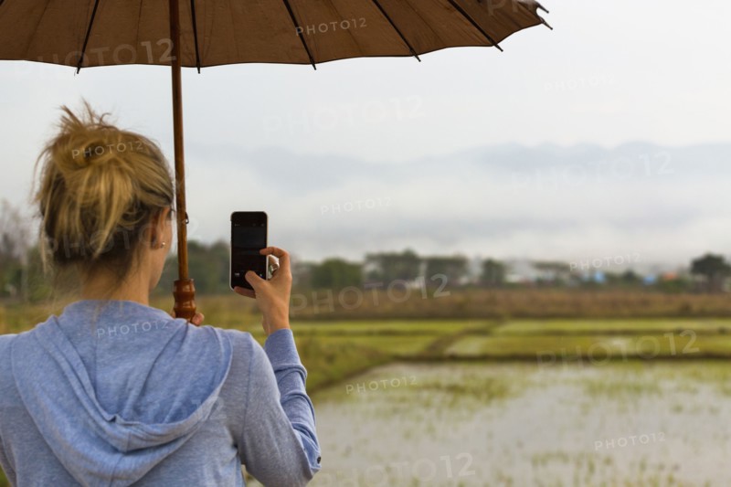 Caucasian woman photographing rural rice fields