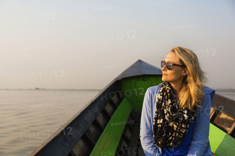 Caucasian woman riding in canoe on rural lake