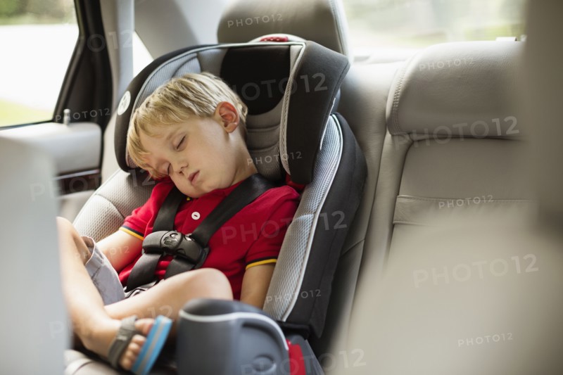 Caucasian boy napping in car seat