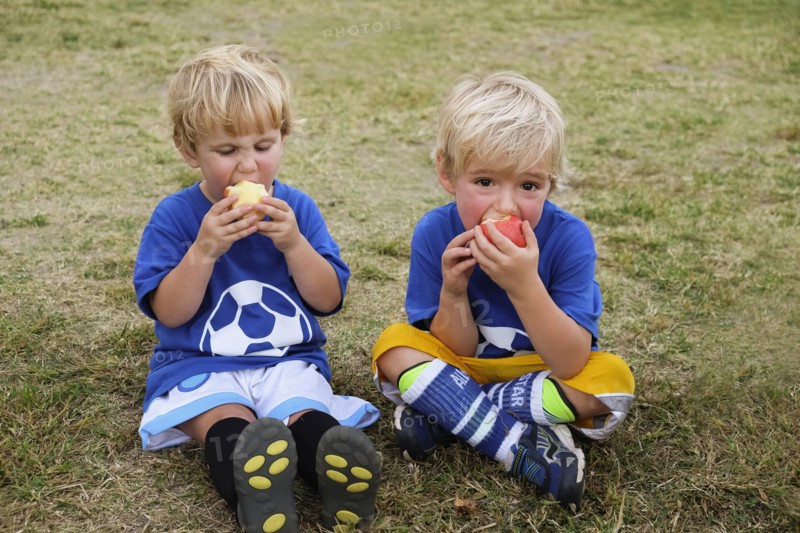 Caucasian soccer players eating apples