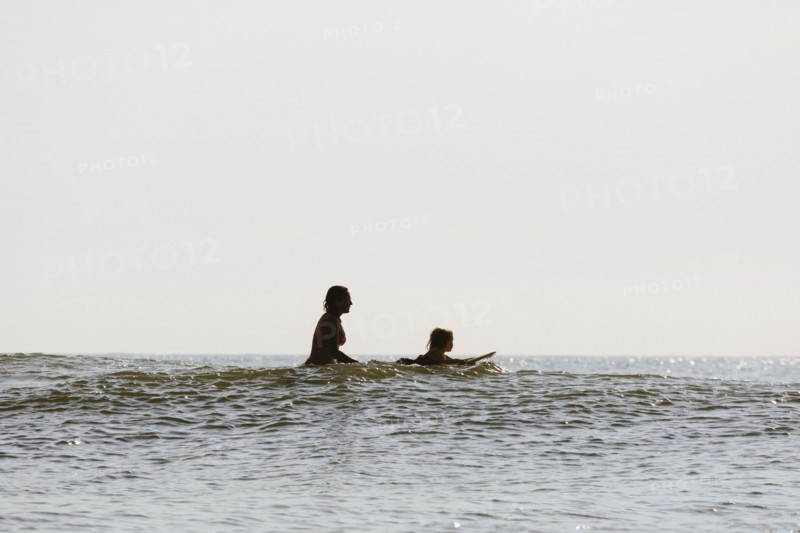 Mother and daughter surfing in waves