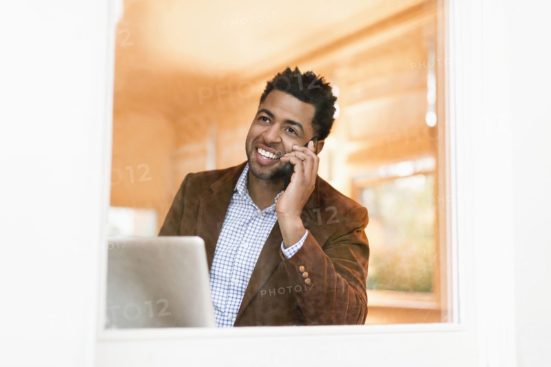 African American businessman talking on cell phone in office