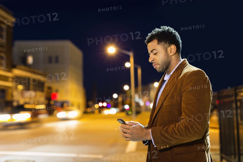 African American businessman using cell phone outdoors