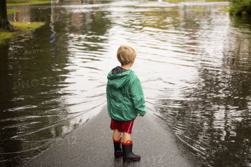 Caucasian boy wearing puddles near flood