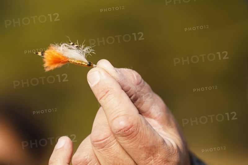 Hand holding fly fishing lure