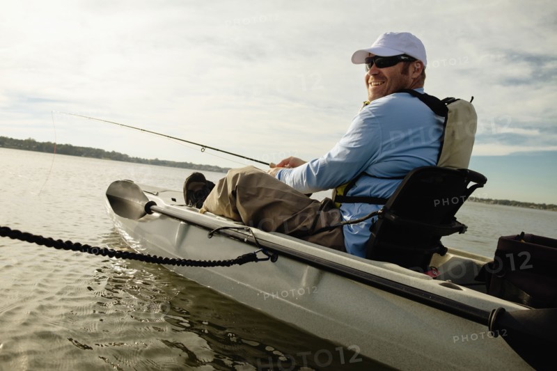 Caucasian man fly fishing in kayak on river