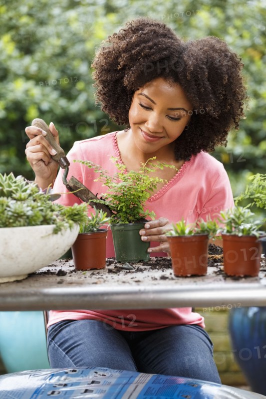 Black woman gardening at table outdoors