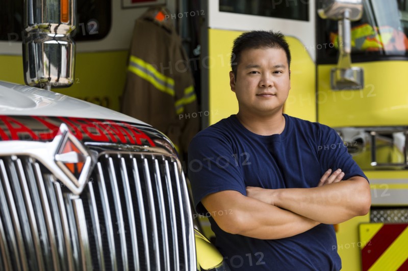 Serious Chinese fireman posing with fire truck