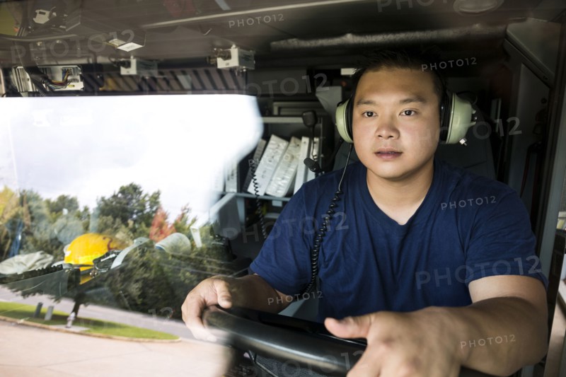 Chinese fireman wearing headphones driving fire truck