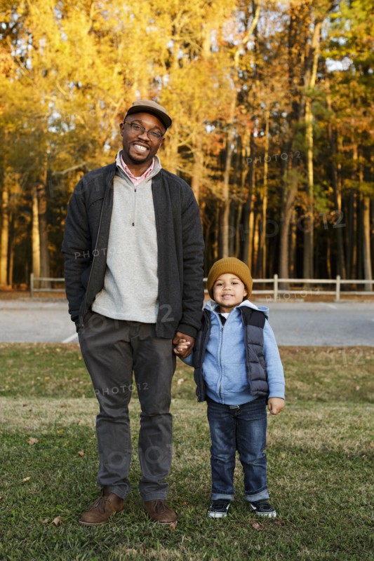 Father and son holding hands in park